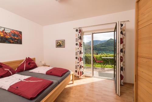 um quarto com uma cama e uma porta de vidro deslizante em Weingut Morandell em Caldaro