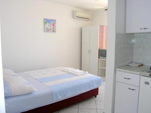 małą sypialnię z łóżkiem i lodówką w obiekcie Apartments Murgic w Krku