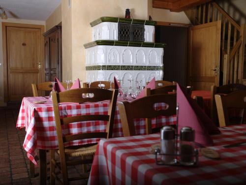 un restaurante con mesas y sillas rojas y blancas a cuadros en Auberge De La Charriole, en Taintrux