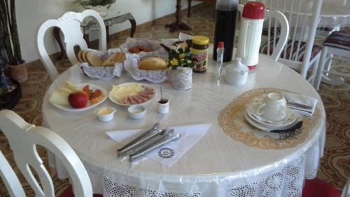 un tavolo con una tovaglia bianca con del cibo sopra di Pousada Charitas Inn a Niterói