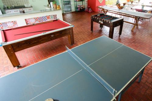 una habitación con 2 mesas de ping pong y una mesa de ping pong en Pousada Tia Nena, en Olímpia
