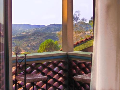 a balcony with two chairs and a view of mountains at Topanga Canyon Inn Bed and Breakfast in Topanga
