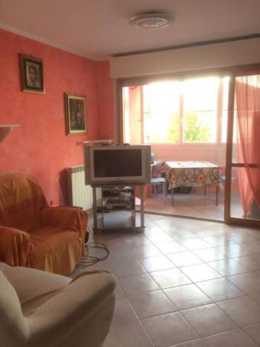Il comprend un salon doté d'une télévision à écran plat et d'un canapé. dans l'établissement A Casa di Andrea, à Ceparana