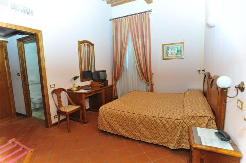 a bedroom with a bed and a desk and a television at Villa La Nina in Montecarlo