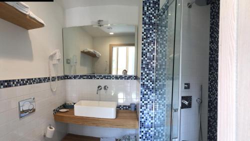 y baño con lavabo y ducha con espejo. en La Casa di Andrea Relais, en Monterosso al Mare
