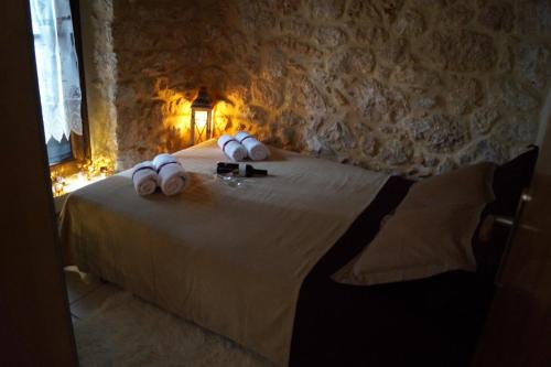 a bedroom with a bed with white pillows on it at Niko's Stone Guest House in Plitra