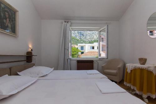 a bedroom with two beds and a window at Villa Mađor in Makarska