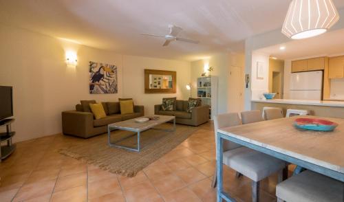 a kitchen and living room with a table and a couch at Byron Quarter Apartments in Byron Bay