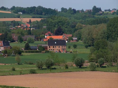 ein großes Haus mitten auf einem grünen Feld in der Unterkunft B&B Hoeve de Schapenkop in Ronse