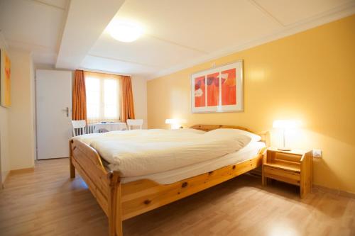 a bedroom with a large bed and a table with two lamps at Hotel Gerig in Wassen