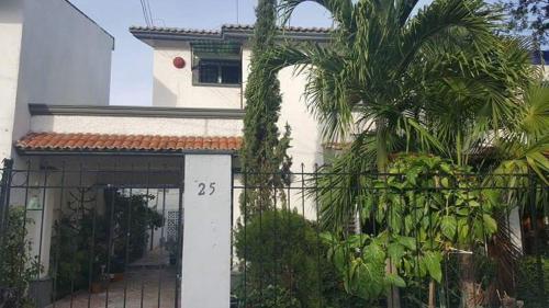a house with a gate and a palm tree at Room in Cancun Stadium in Cancún