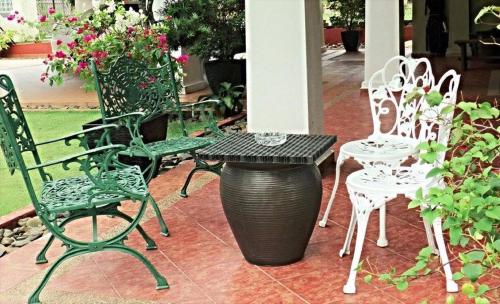 Un grupo de sillas y una mesa y un bote de basura. en CasaPelindung Guesthouse, en Kuantan