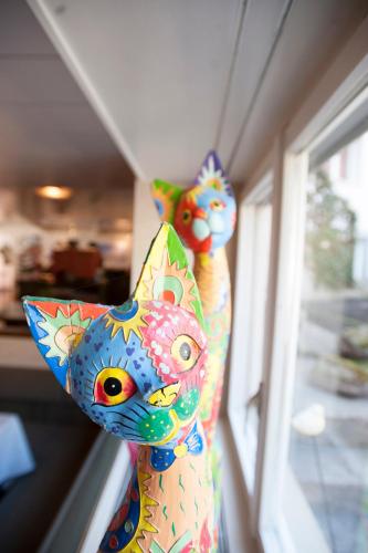 two colorful statues of cats on a window sill at Hotel Gerig in Wassen