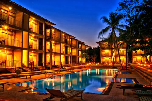 a hotel with a swimming pool in front of a building at Fresco Water Villa in Sigiriya