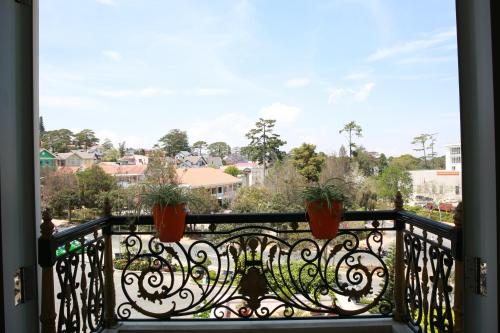 a balcony with potted plants and a view of a city at Sammy Dalat Hotel in Da Lat