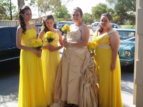 a group of women in yellow dresses holding flowers at A Good Rest B & B in Alice Springs