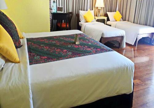a hotel room with two beds with a flower blanket at Baan Bayan - Hua Hin - SHA Extra Plus in Hua Hin