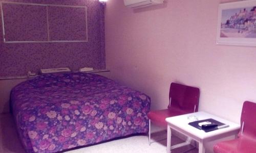 a bedroom with a bed and a table and a chair at Hotel Tea Time (Love Hotel) in Nagasaki