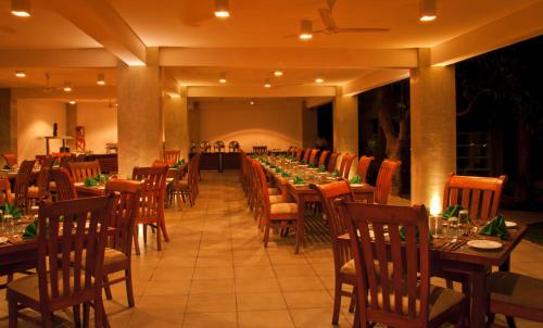 a long dining room with tables and chairs at Fresco Water Villa in Sigiriya
