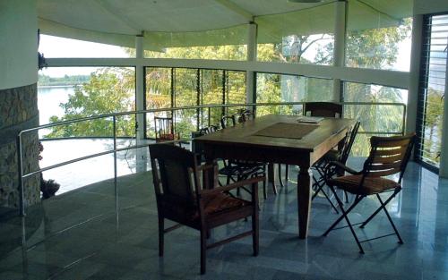 a table and chairs on a screened in porch at Air Manis Hill Residence in Padang