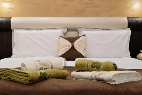 1 dormitorio con 1 cama con almohadas y toallas en Apartments in Relax Complex Fantasy, en Hisarya