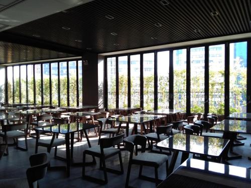 a restaurant with tables and chairs and large windows at Southern-Club Station 1 Hotel in Guangzhou