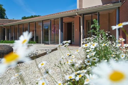 a building with windows and flowers in the foreground at Cit'Hotel Les Alizés in Limoges