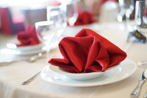 a white plate with red napkin on a table at Sammy Dalat Hotel in Da Lat
