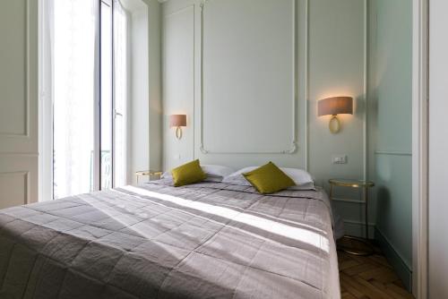 a bedroom with a large bed with two yellow pillows at Hotel Eden Alaxi Hotels in Alassio