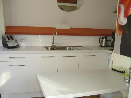 a kitchen with white cabinets and a sink at Studio Zandvoort in Zandvoort
