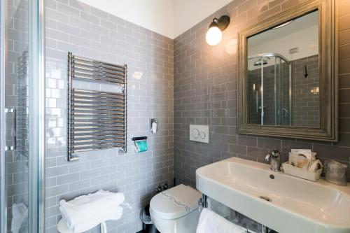 a bathroom with a sink and a toilet and a mirror at Hotel Eden Alaxi Hotels in Alassio