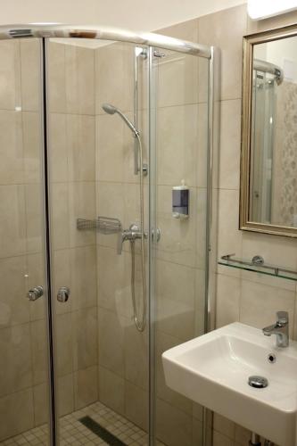 a bathroom with a shower and a sink at Stefánia Stúdió Apartmanok in Szeged
