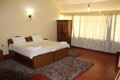 a bedroom with a bed with white sheets and white pillows at Sirukundra Garden Bungalow in Vālpārai