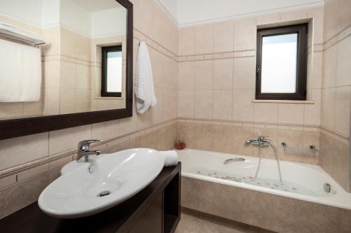a bathroom with a sink and a bath tub at Villa Stellina in Marathokefála