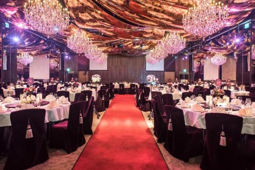 a banquet hall with tables and chairs and chandeliers at Palais de Chine Hotel in Taipei