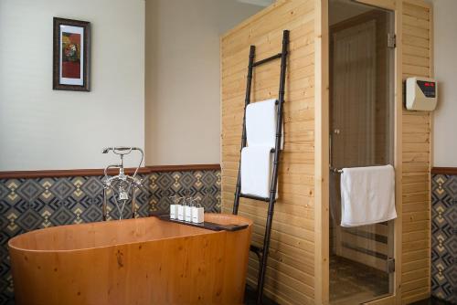 a wooden tub in a bathroom with a shower at La Siesta Hoi An Resort & Spa in Hoi An