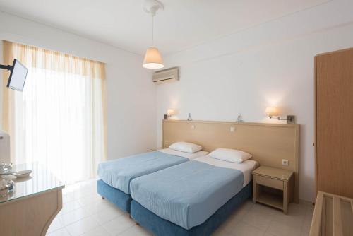 a bedroom with a blue bed and a window at Erato Apartments in Petalidi