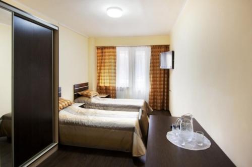 a hotel room with two beds and a table at Tsaghkahovit Hotel in Tsaghkadzor