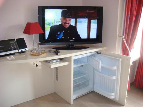 einen TV auf einem Schreibtisch mit einem Fernseher darauf in der Unterkunft Gastenkamers Centersuites in Oostduinkerke