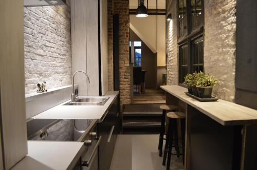 a kitchen with a sink and a counter top at De Waterzooi Lodge in Ghent