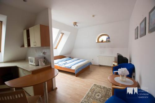 pequeña sala de estar con cama y cocina en Kulturne Centrum Bardejov, en Bardejov
