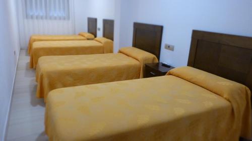 a group of four beds in a room at Hostal Restaurante La Masía in Villareal