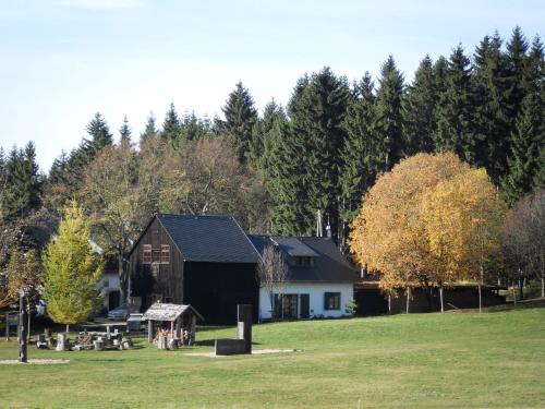 a house in the middle of a field with trees at Altsächsischer Gasthof Kleines Vorwerk in Sayda