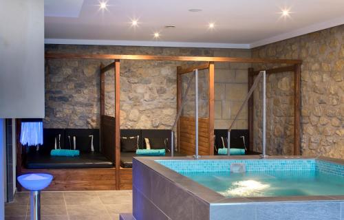 a bathroom with a hot tub in a room at Domaine de la Klauss & Spa, Restaurant Gastronomique Le K in Montenach