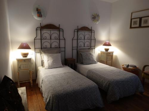 1 dormitorio con 2 camas y 2 lámparas en las mesas en Chambres d'Hôtes A Buglose, en Saint-Vincent-de-Paul