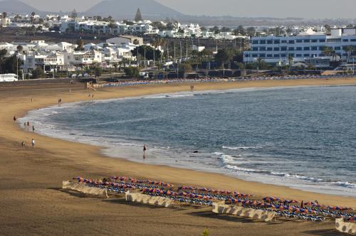 a group of people on a beach near the water at VIK Hotel San Antonio in Puerto del Carmen