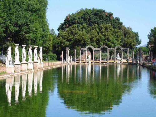 a pool of water with statues in a park at Villa Tivoli in Guidonia