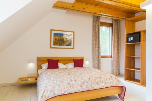 ein Schlafzimmer mit einem großen Bett mit roten Kissen in der Unterkunft Moor-Rosl Apartmenthotel in Gamlitz