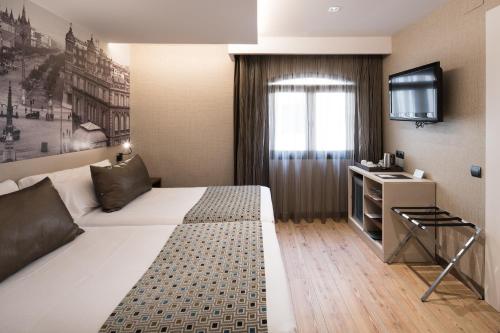 a hotel room with a bed and a television at Catalonia Born in Barcelona