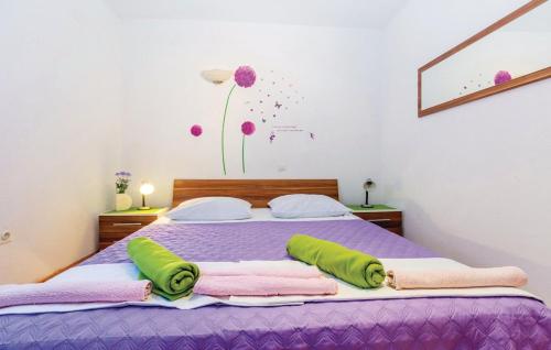 een bed met paarse lakens en groene kussens erop bij Apartment Ivan Mili in Senj